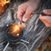 Nærbilde av FireSteel Scout cocoshell tennstål med signalpipe
